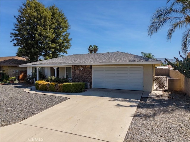ranch-style home featuring a gate, driveway, an attached garage, fence, and stucco siding