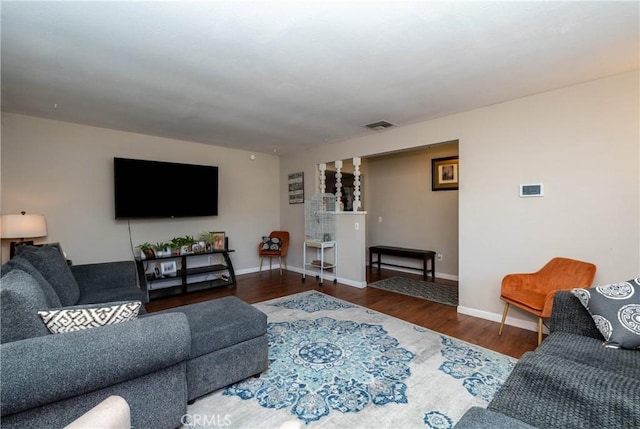 living area with wood finished floors, visible vents, and baseboards