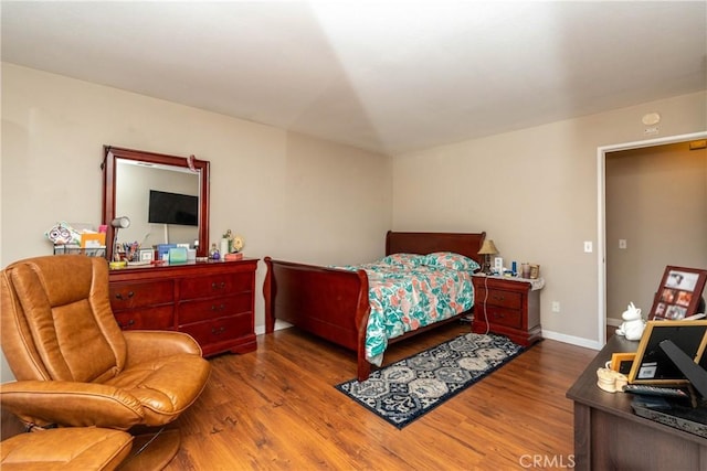 bedroom featuring baseboards and wood finished floors