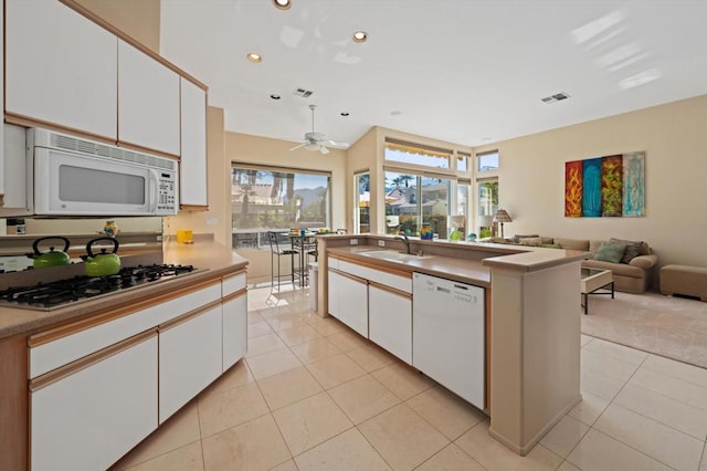 kitchen featuring white cabinets, white appliances, and light tile patterned floors