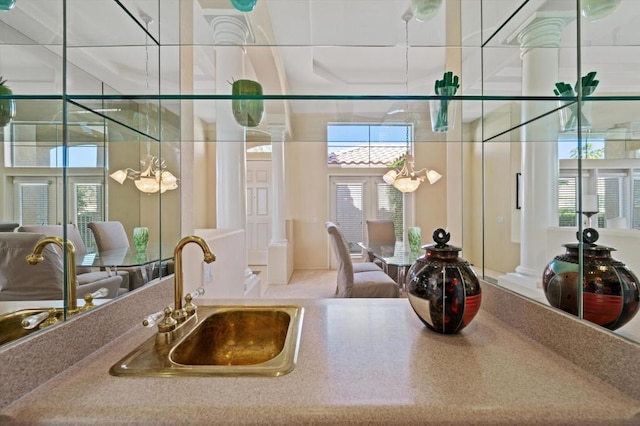 kitchen with decorative columns, sink, and a chandelier