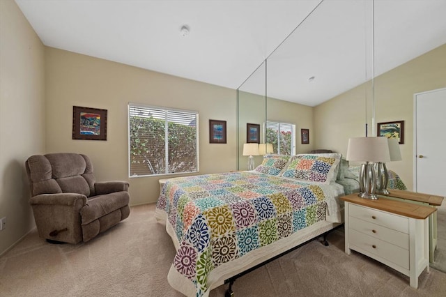 bedroom with light colored carpet and lofted ceiling