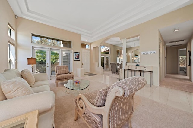 living room with a raised ceiling, ornate columns, a high ceiling, and light tile patterned floors