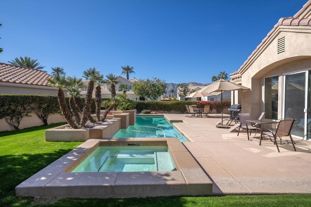 view of swimming pool with an in ground hot tub, grilling area, a patio area, and a lawn