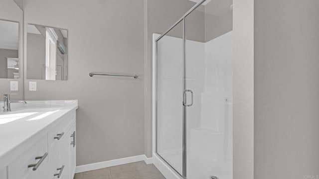 bathroom featuring tile patterned flooring, vanity, and a shower with shower door