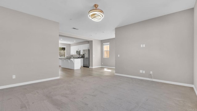 unfurnished living room featuring light carpet