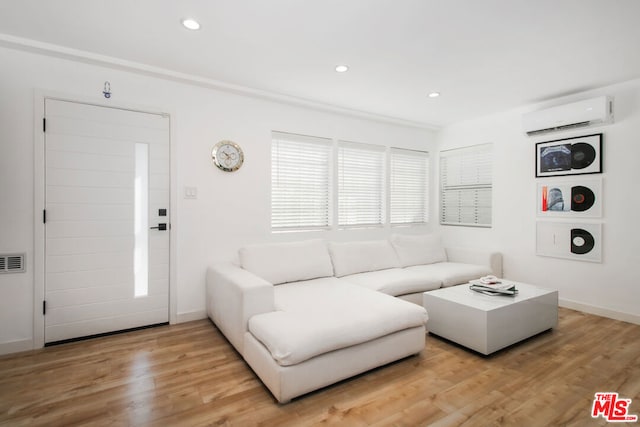 living room with a wall unit AC and light wood-type flooring