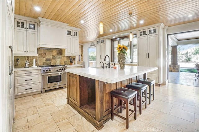 kitchen with a center island with sink, white cabinets, and stainless steel appliances