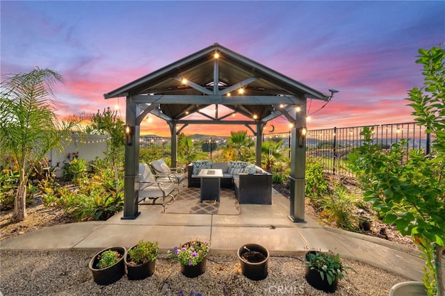 patio terrace at dusk featuring a gazebo and an outdoor living space