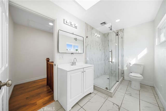 bathroom featuring wood-type flooring, vanity, toilet, and a shower with door