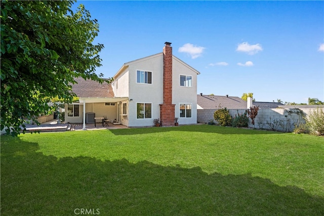 back of property featuring a yard and a patio