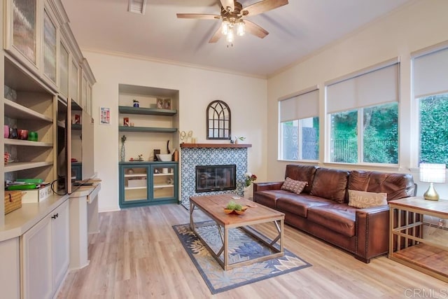 living room with plenty of natural light, light wood-type flooring, and ornamental molding