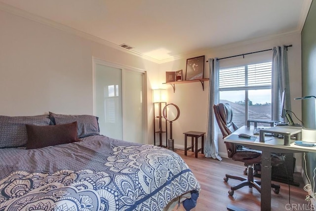 bedroom featuring light hardwood / wood-style floors and ornamental molding