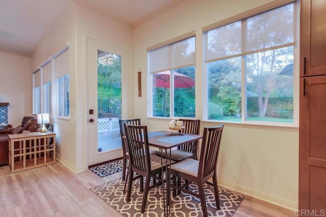 dining area with light hardwood / wood-style floors and crown molding