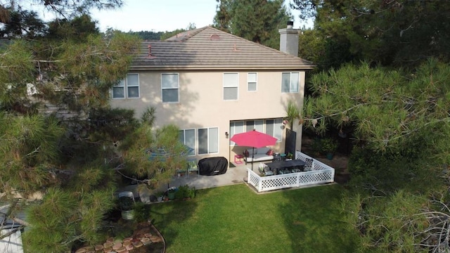 rear view of house featuring a patio area and a yard