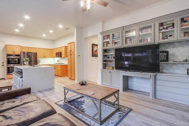 living room with light hardwood / wood-style flooring, ceiling fan, ornamental molding, and sink