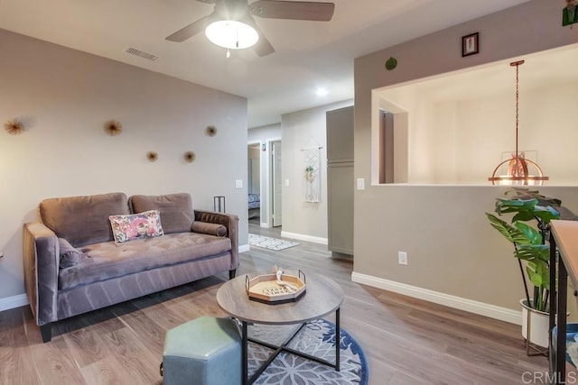 living room featuring hardwood / wood-style floors and ceiling fan