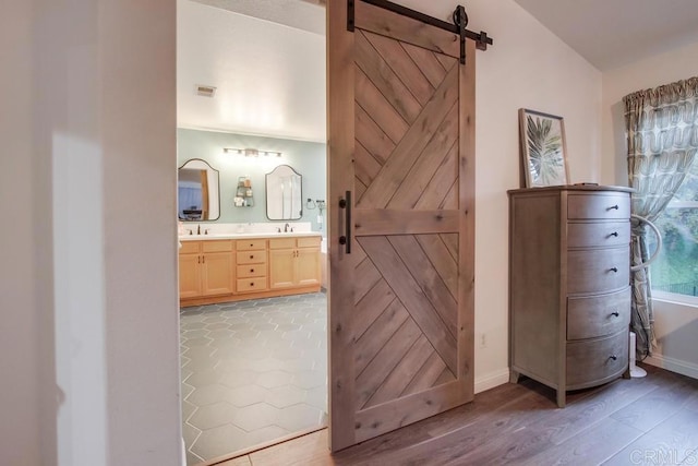 bathroom featuring hardwood / wood-style flooring, vanity, and vaulted ceiling