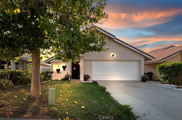 view of front of home with stucco siding, concrete driveway, an attached garage, and a tiled roof