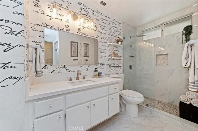 bathroom with vanity, toilet, and a shower with door