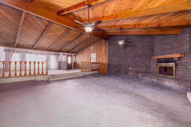 interior space featuring lofted ceiling with beams, ceiling fan, concrete floors, wood ceiling, and brick wall