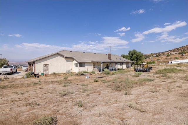 back of house featuring central AC and a mountain view