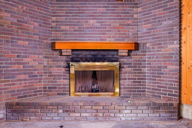 details featuring concrete flooring and a brick fireplace