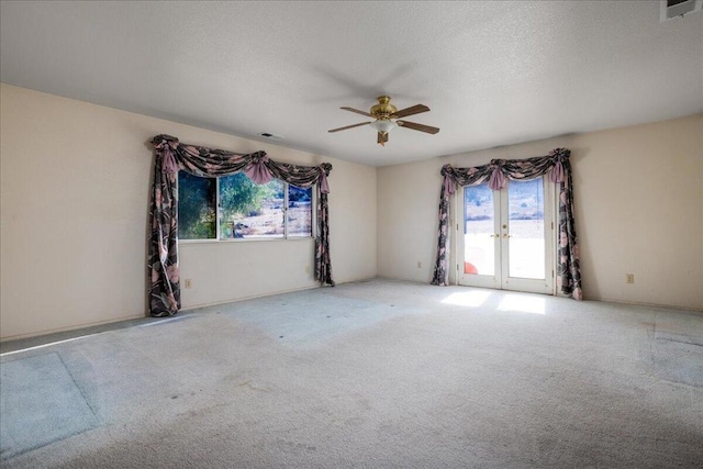 carpeted empty room featuring ceiling fan and a textured ceiling