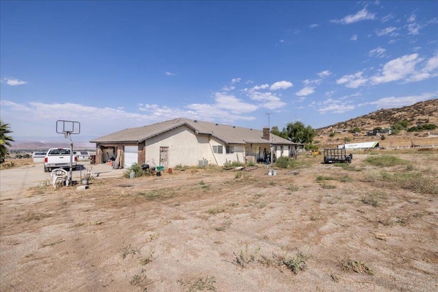 rear view of house with a mountain view and a garage