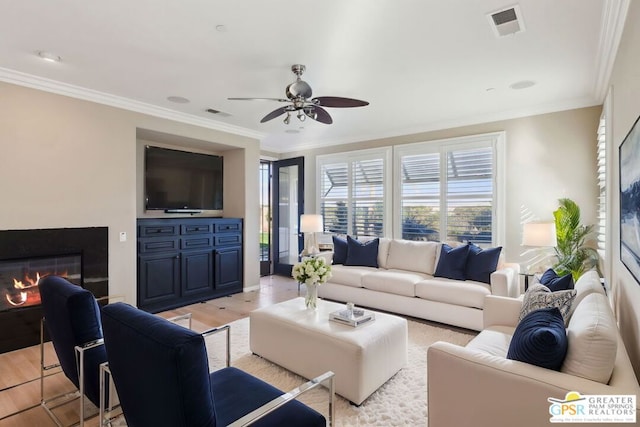 living room featuring crown molding, ceiling fan, and light hardwood / wood-style flooring