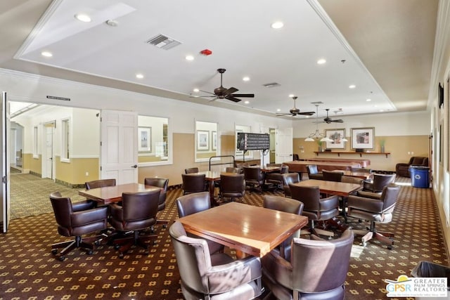 carpeted dining room featuring a raised ceiling and ornamental molding