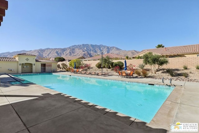 view of swimming pool featuring a mountain view and a patio