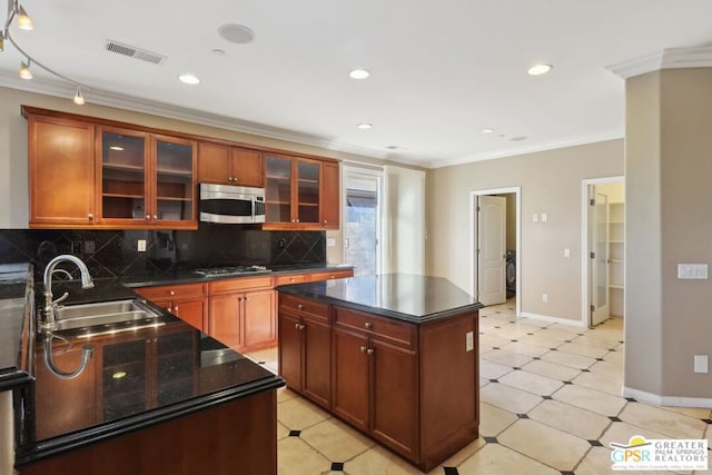 kitchen with sink, stainless steel appliances, a center island, ornamental molding, and decorative backsplash