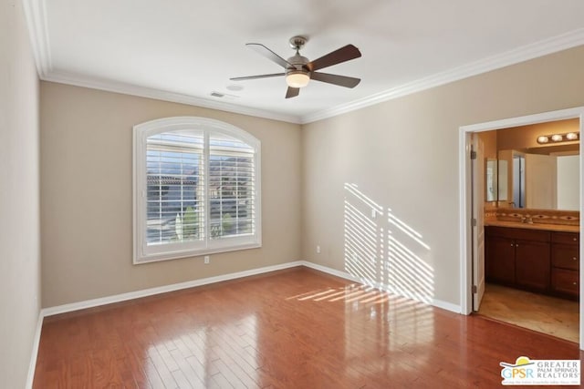 spare room featuring hardwood / wood-style flooring, crown molding, sink, and ceiling fan