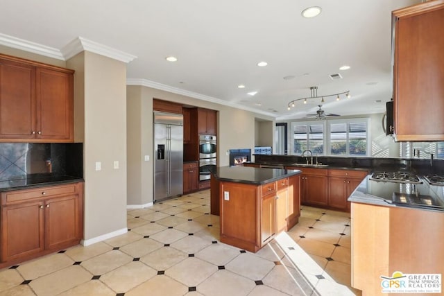 kitchen featuring stainless steel appliances, crown molding, a kitchen island, and sink