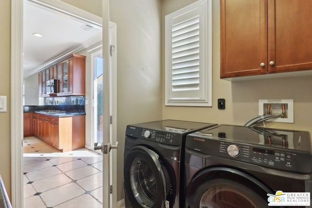 washroom with cabinets, ornamental molding, and separate washer and dryer