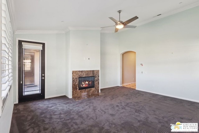 unfurnished living room with dark colored carpet, ornamental molding, lofted ceiling, and a fireplace