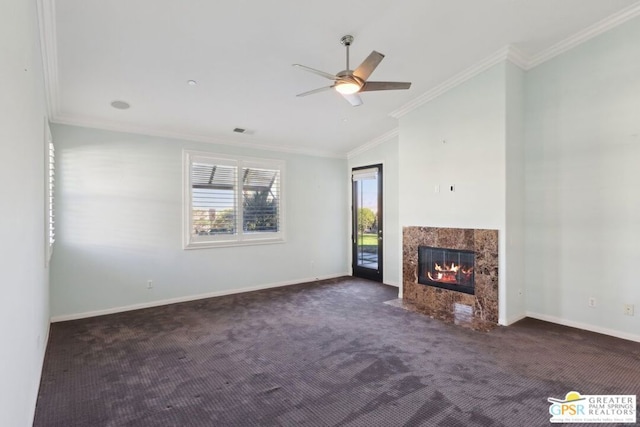 unfurnished living room with lofted ceiling, crown molding, dark carpet, ceiling fan, and a high end fireplace