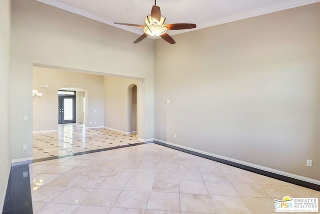 tiled spare room featuring ornamental molding and ceiling fan