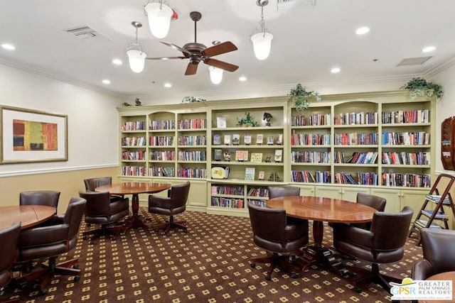 sitting room featuring dark carpet, crown molding, and ceiling fan