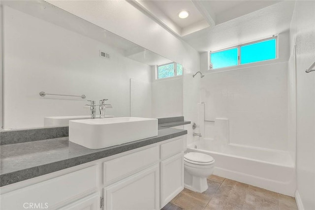 full bathroom with tile patterned flooring, vanity, tiled shower / bath combo, and toilet