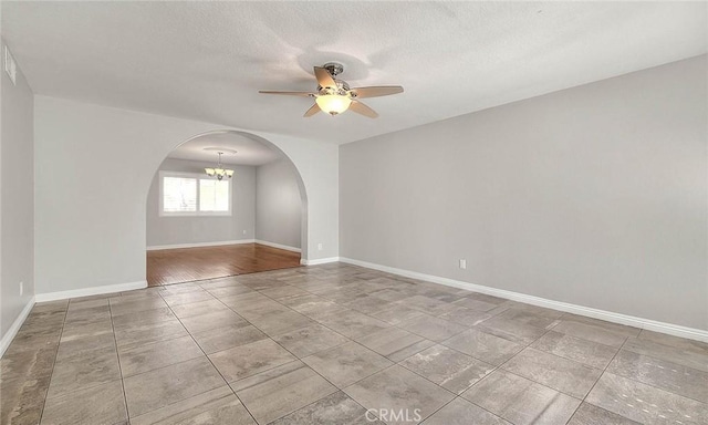 empty room with a textured ceiling, ceiling fan with notable chandelier, and light hardwood / wood-style flooring