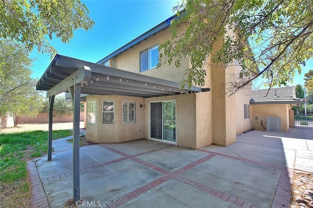 rear view of house with a patio area and central AC