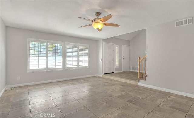 empty room with ceiling fan and light tile patterned floors