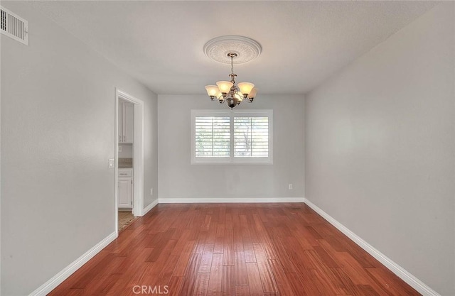 unfurnished dining area with hardwood / wood-style flooring and an inviting chandelier