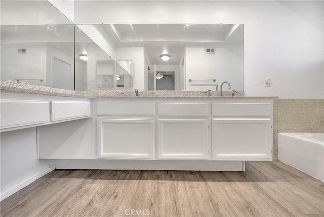 bathroom with wood-type flooring, vanity, and a bathing tub