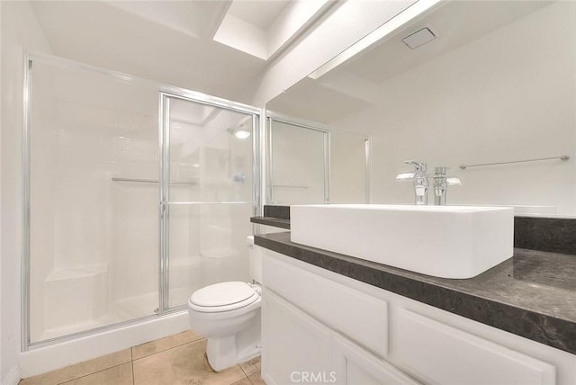 bathroom with tile patterned flooring, vanity, toilet, and a shower with shower door