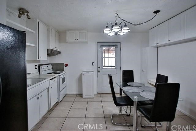 kitchen featuring white cabinets, white electric range, hanging light fixtures, and black fridge