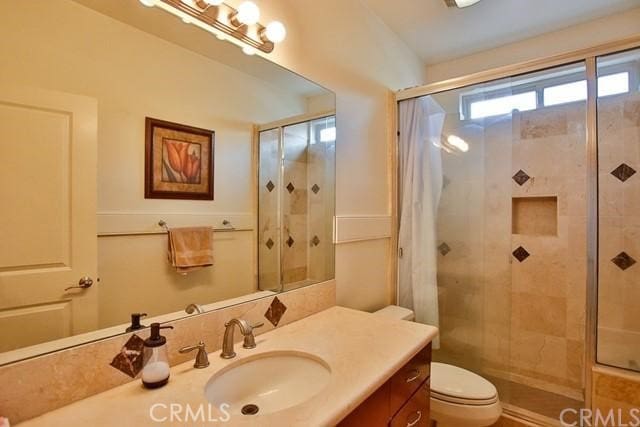 bathroom with curtained shower, vanity, and toilet