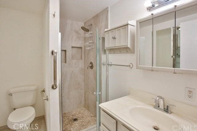 bathroom with vanity, toilet, and a shower with shower door